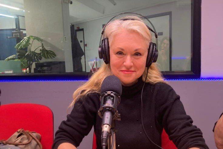 Cristina con auriculares ante el micrófono en el estudio de ADN Informativo