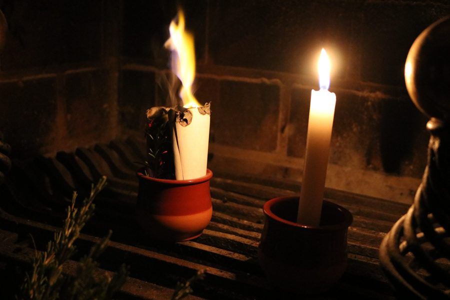 Un papel ardiendo junto a una vela en un ritual para soltar lo heredado